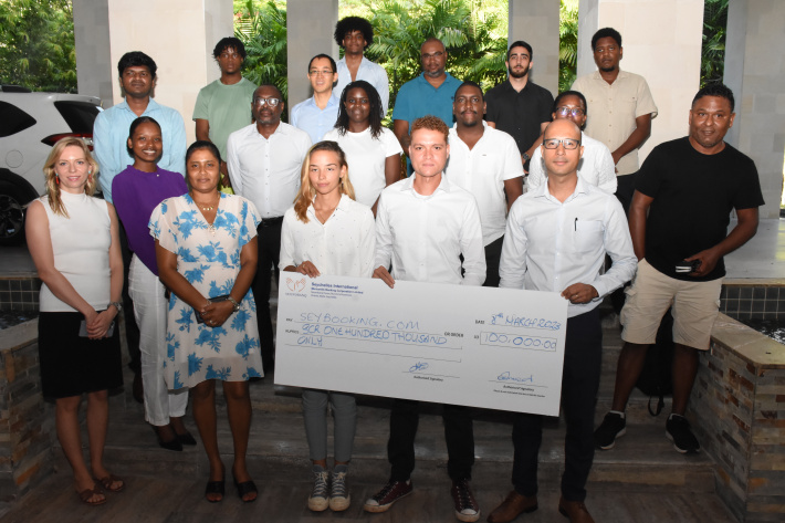 Salim Mathieu and the SeyBooking team holding the winning SCR 100,000 cheque